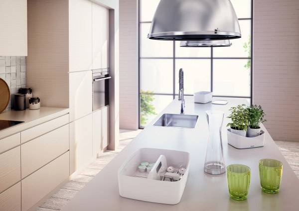 Nowoczesna kuchnia z dużym oknem, centralną wyspą kuchenną, zlewem, przezroczystymi naczyniami i doniczkami z ziołami. Jasne, minimalistyczne wnętrze.