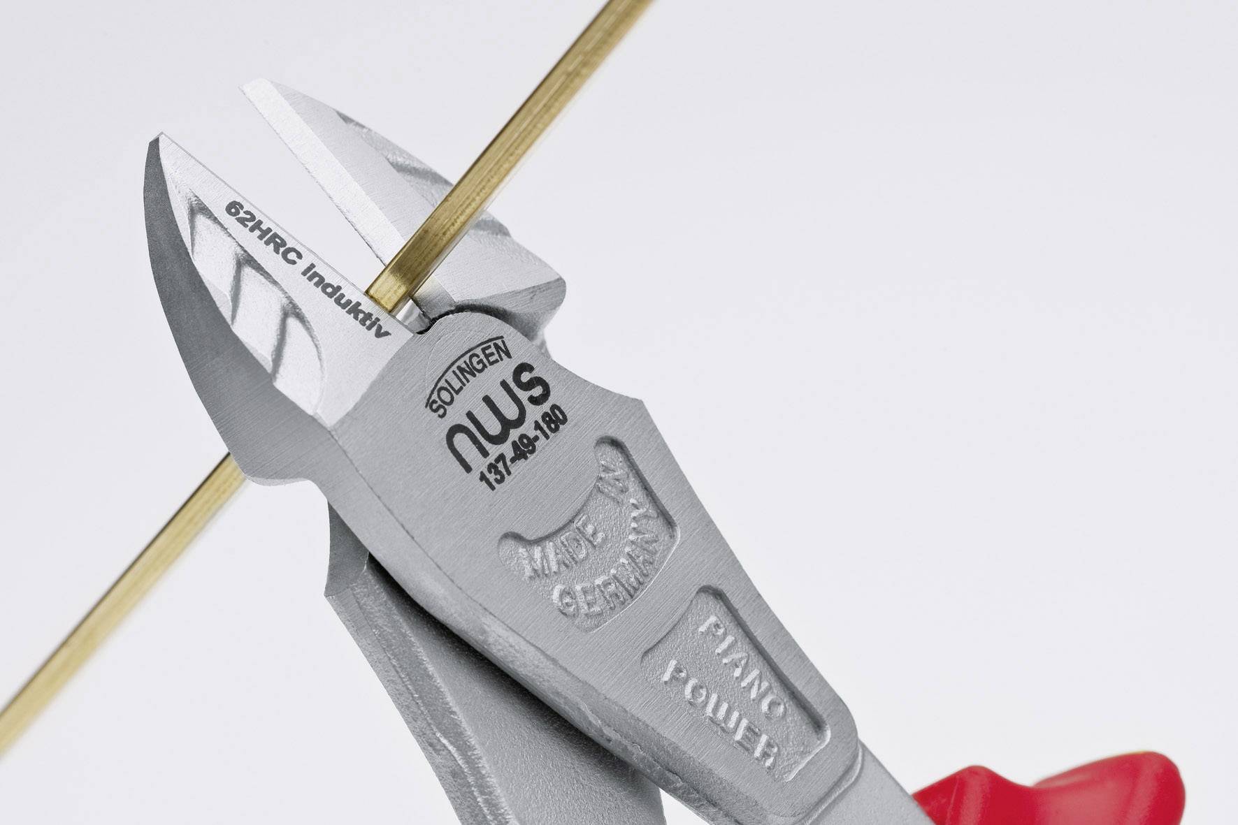 Czerwone szczypce do cięcia przewodów przecinają cienki, złotawy drut. Na szczypcach widoczny jest napis 'Made in Germany' oraz 'NWS'.