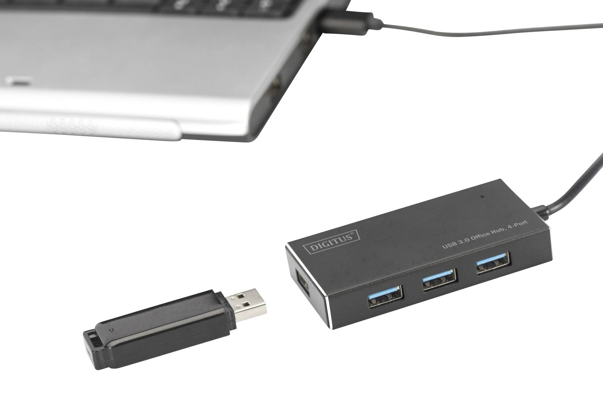 Koncentrator USB 3.0 z czterema portami łączy się z laptopem; obok leży pendrive.