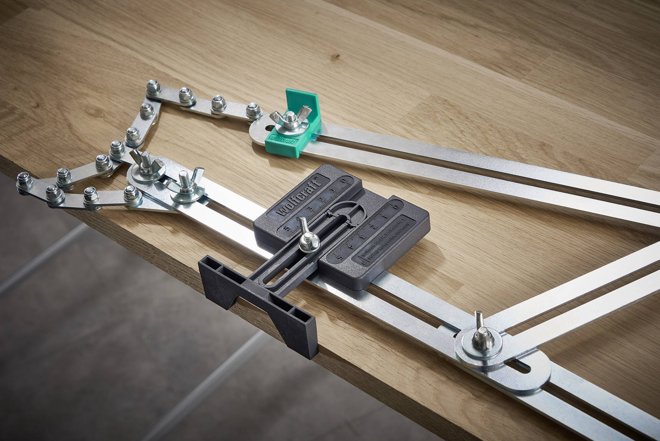 Urządzenie do wiercenia kołków jest zamocowane na drewnianej płycie. Posiada metalowe szyny z zaciskami śrubowymi do precyzyjnego określania odległości między otworami.