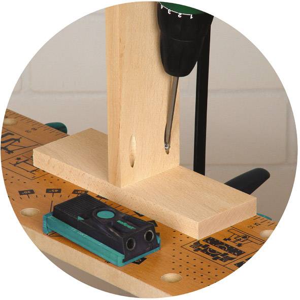 'Wiertarka obrabia kawałek drewna na stole z podziałką, podczas gdy kątomierz leży obok.'