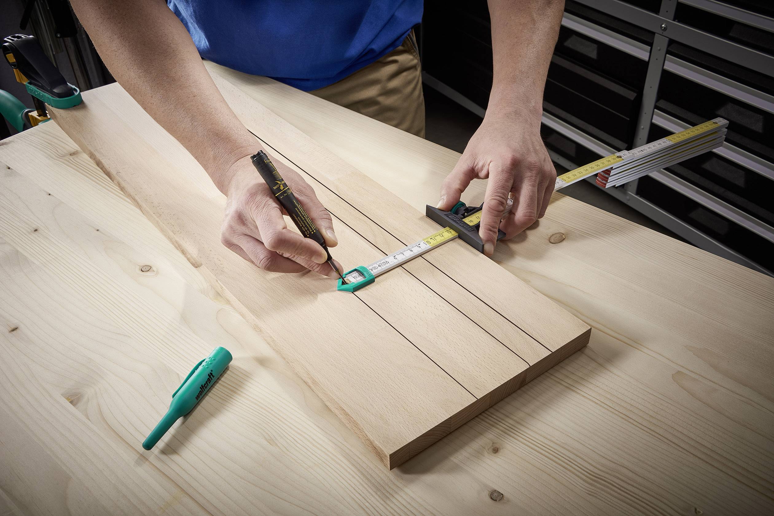 Osoba mierzy za pomocą miarki i oznacza deskę drewnianą. Scena przedstawia precyzję podczas obróbki drewna.