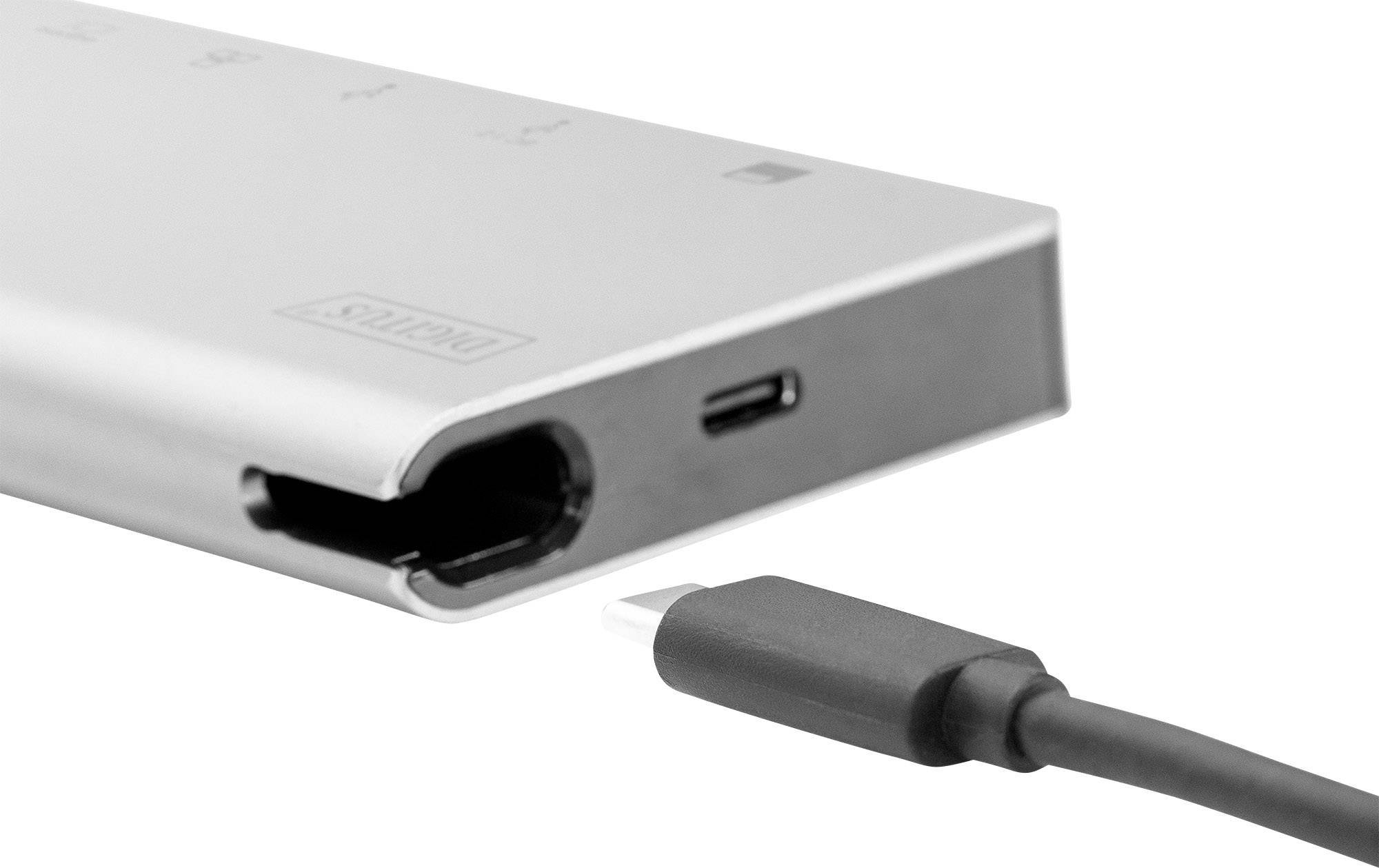 Wtyczka USB-C leży przed koncentratorem USB-C z wieloma portami. Nacisk położony jest na kompatybilność urządzeń.