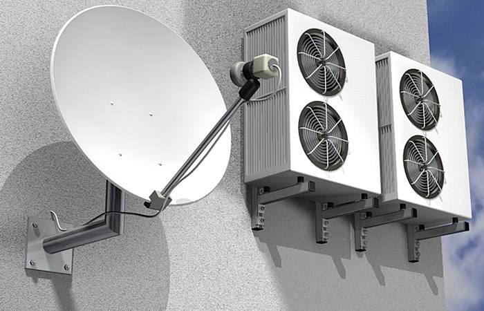 Antena satelitarna i trzy jednostki zewnętrzne klimatyzacji zamontowane na elewacji budynku.