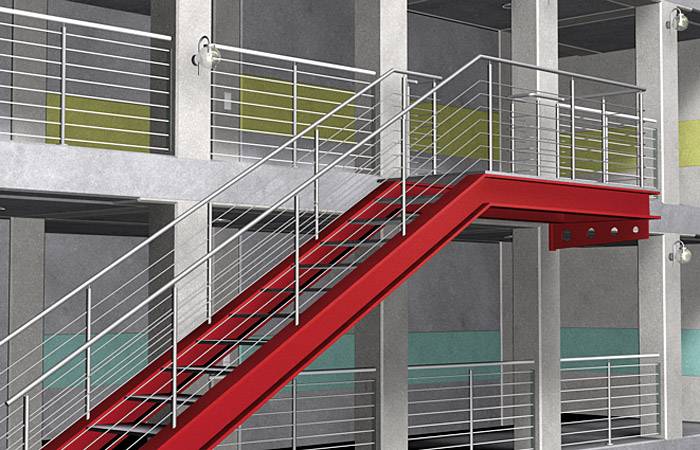 Czerwone schody w nowoczesnym budynku z metalowymi poręczami i betonowymi ścianami, prowadzące do górnej kondygnacji z balkonami.