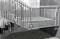 Betonowe schody z metalową balustradą w nowoczesnym budynku. Projekt jest minimalistyczny, z elementami betonu i metalu.