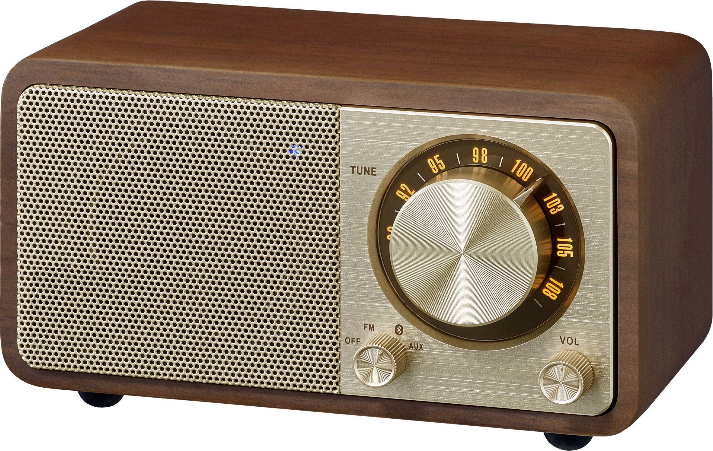 Drewniane radio z metalową kratką, dużym pokrętłem do strojenia i skalą częstotliwości. Po lewej stronie: głośnik, po prawej stronie: regulatory głośności i częstotliwości.