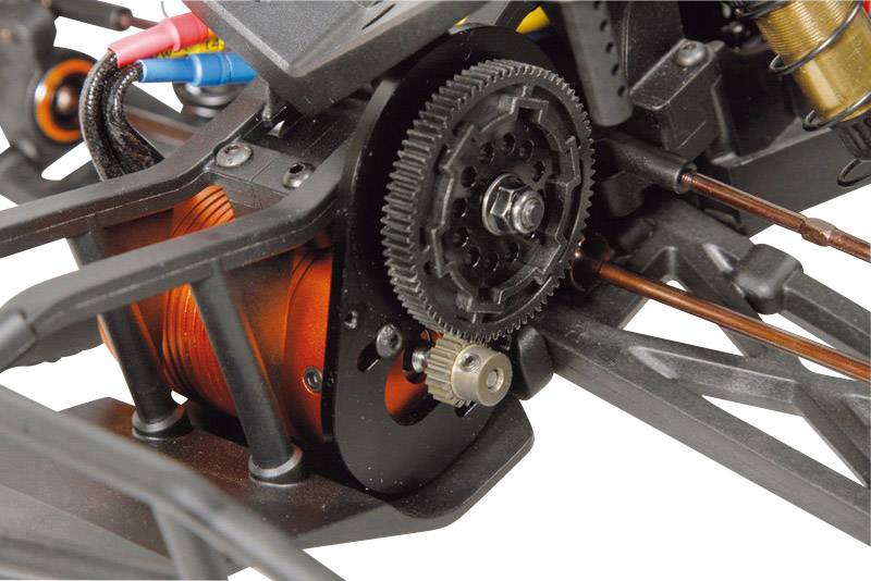 Zbliżenie mechanicznego elementu z kołem zębatym i obracającym się silnikiem elektrycznym, otoczonym metalowymi podporami i kablami.