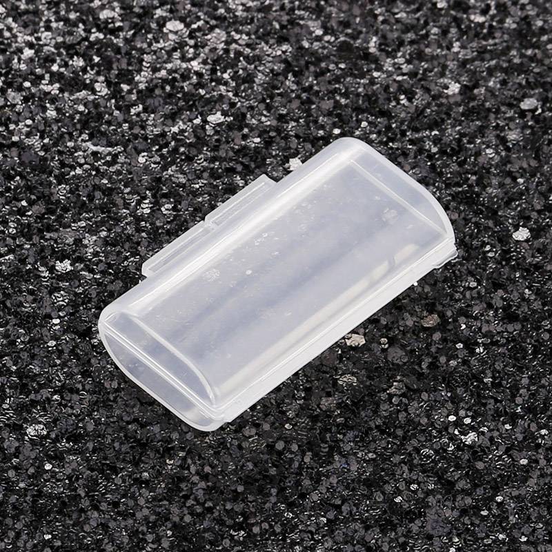 Przezroczysty, prostokątny pojemnik z tworzywa sztucznego leży na czarnej, strukturalnej powierzchni.