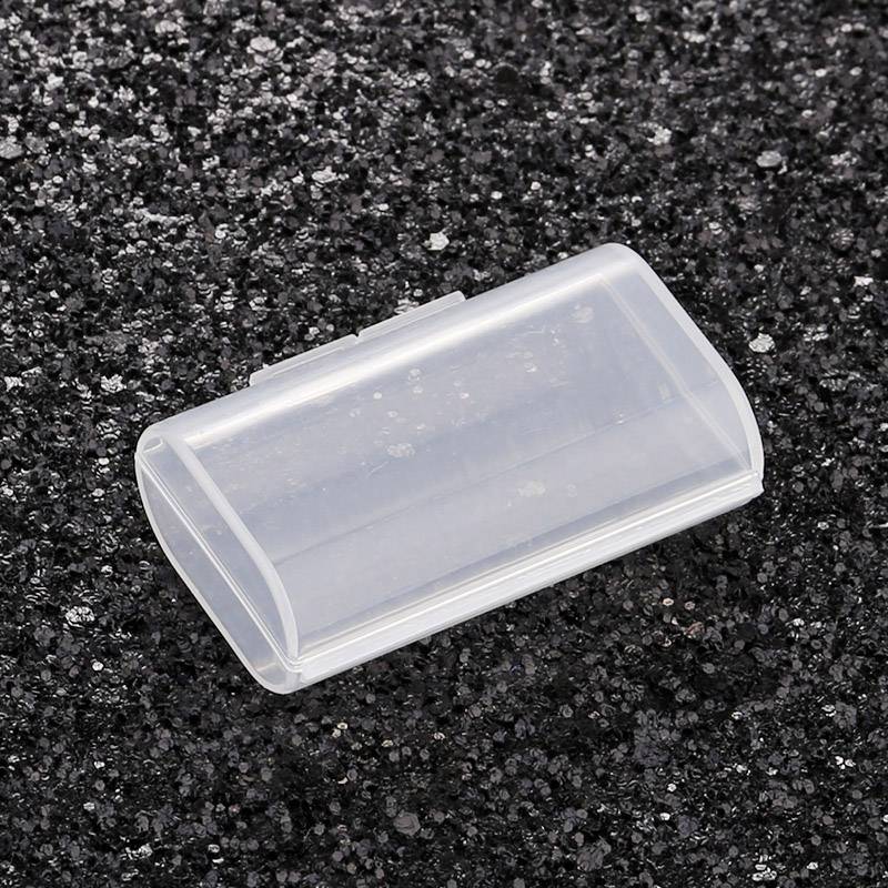 Przezroczyste pudełko z tworzywa sztucznego na czarnym, ziarnistym tle.