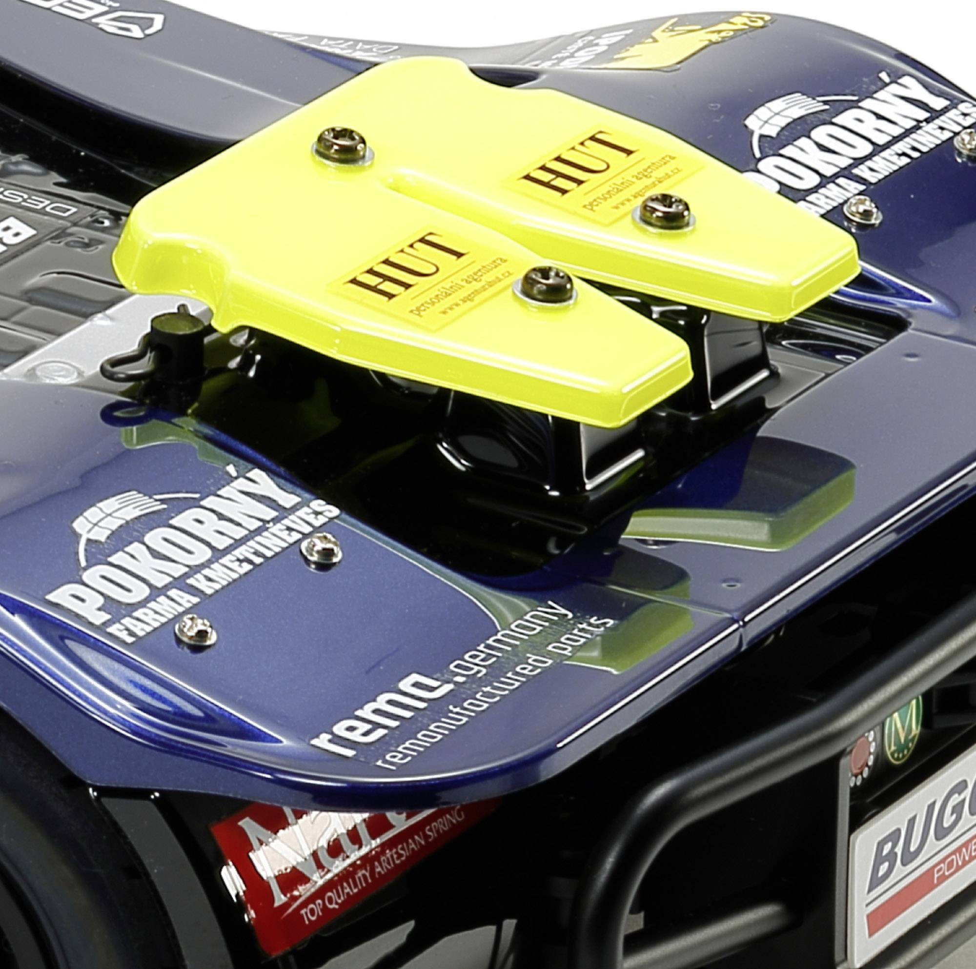 Tylna część samochodu wyścigowego z żółtym spoilerem i logo różnych marek, w tym 'POKORNY Frank Remax', 'HUT' oraz 'Buggyra'.