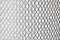 Gęsta siatka druciana na jasnym tle.