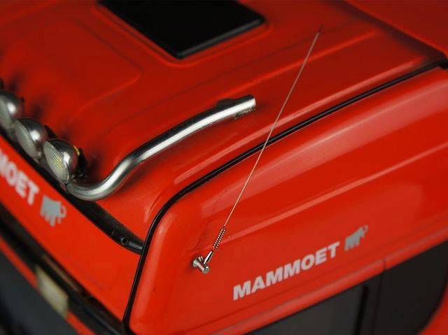 Czerwony, lakierowany model ciężarówki z logo 'Mammoet' i małą metalową anteną na masce.