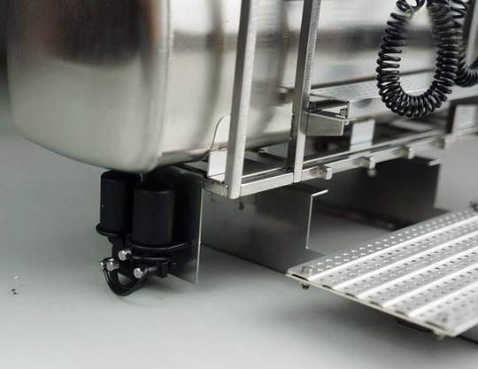 Metalowy zbiornik z przymocowanymi elementami i drabiną. Widoczne połączenia i rury. Element większej maszyny lub instalacji.