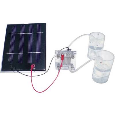 Moduł solarny podłączony przewodami do modelu ogniwa paliwowego wodorowego, zasilającego dwa szkła laboratoryjne napełnione wodą.