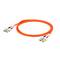 Pomarańczowy kabel światłowodowy z wtyczkami na obu końcach, przeznaczony do szybkich transmisji danych w sieciach.