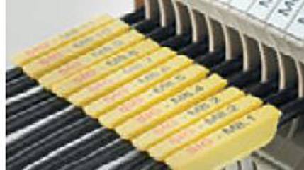 Rząd oznaczonych żółtych przewodów w rozdzielni elektrycznej.