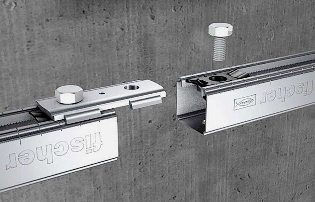 Dwie szyny montażowe przeznaczone do zamocowania na ścianie betonowej, połączone śrubami i nakrętkami, prezentują proces instalacji.