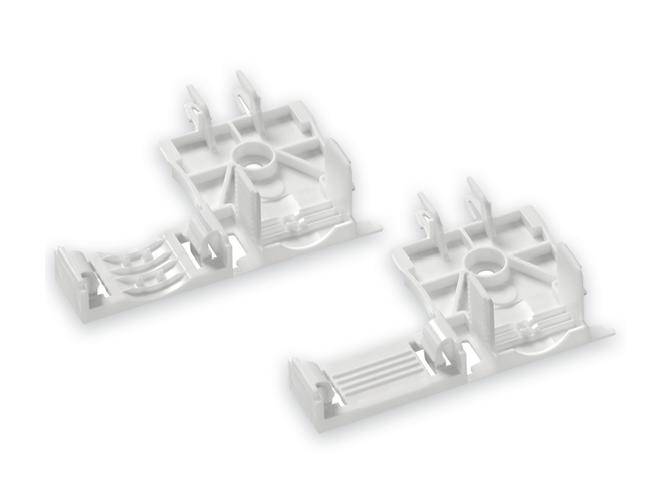 Białe elementy z tworzywa sztucznego o złożonych kształtach, składające się z wielu płaszczyzn i wycięć, prawdopodobnie części do urządzeń technicznych.