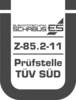 Logo z napisem 'ELEKTROTECHNIKA SCHABUS', poniżej 'Z-85.2-11', następnie 'Placówka badawcza TÜV SÜD', ujęte w stylizowaną ramkę w kształcie litery U.
