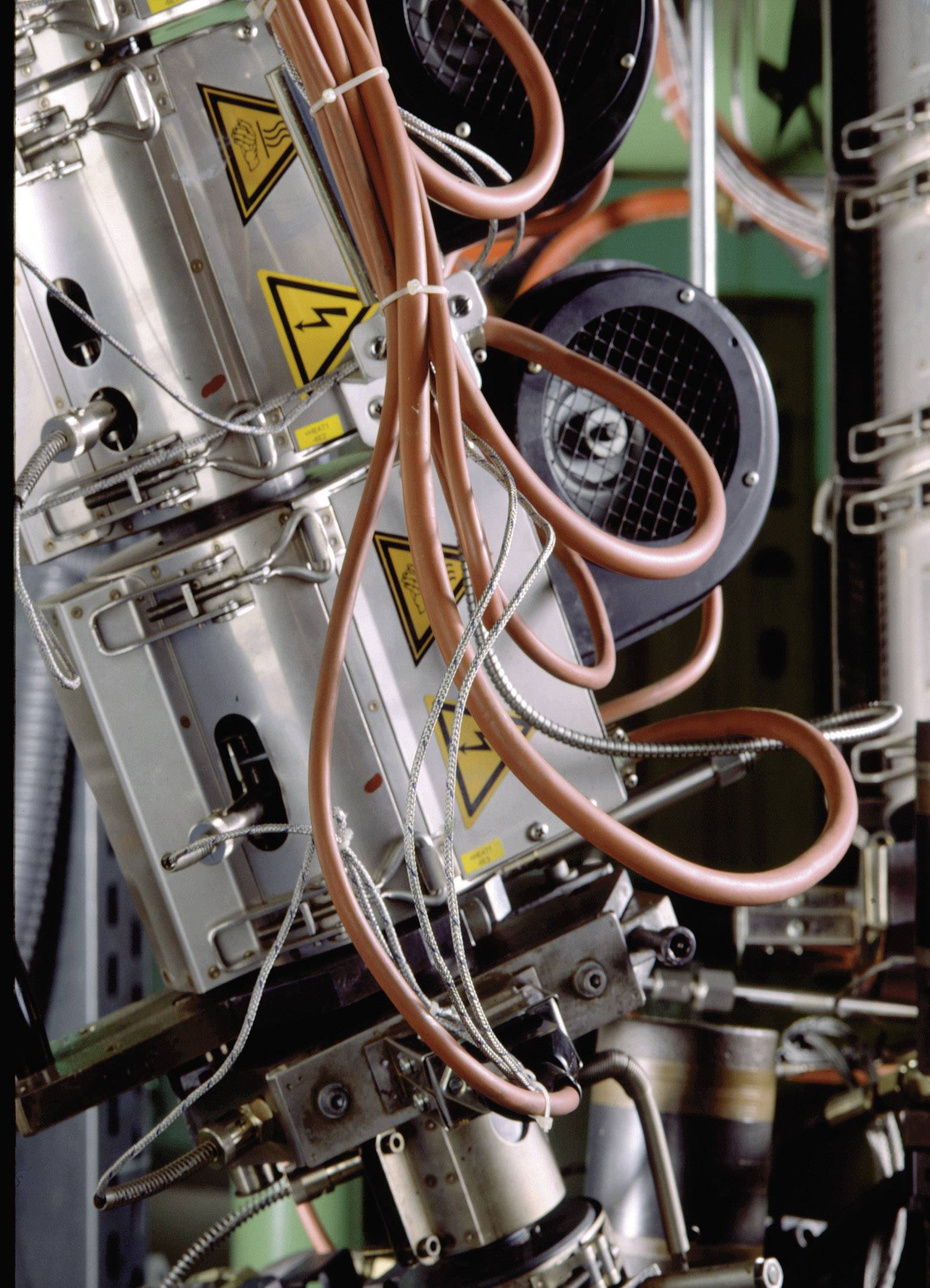 Maszyna przemysłowa z kablami i tabliczkami ostrzegawczymi; przedstawia wyposażenie techniczne i szczegóły okablowania.