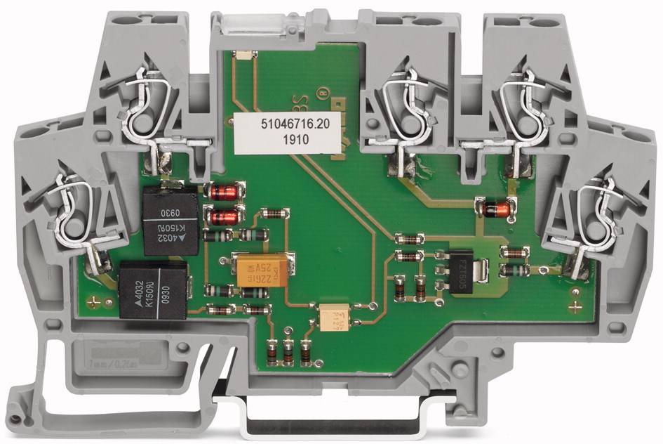 Płytka elektroniczna o zielonej powierzchni w szarej plastikowej obudowie, zawierająca kilka rezystorów i elementów elektronicznych.