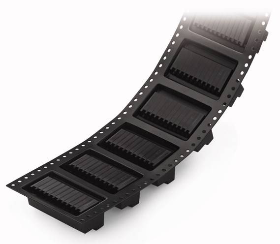 Wygięty rząd czarnych mikroprocesorów w opakowaniu transportowym lub magazynowym.