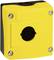 Żółta obudowa z tworzywa sztucznego z okrągłym wycięciem pośrodku i czterema widocznymi śrubami w narożnikach, odpowiednia dla wyłącznika awaryjnego.
