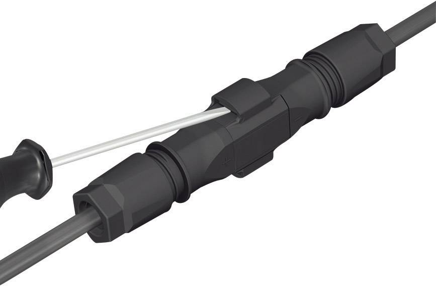 Czarny złącznik kablowy łączy dwa przewody, zapewniając bezpieczne połączenie elektryczne.