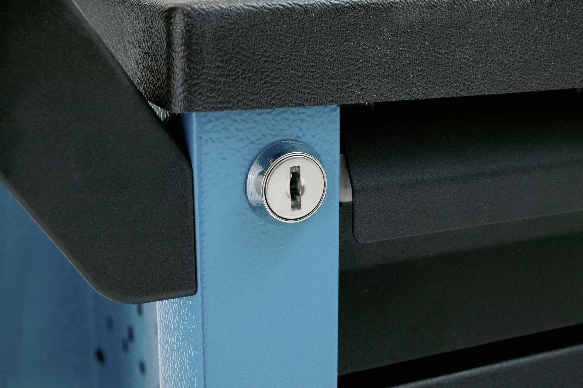 Zbliżenie zamka w niebieskiej metalowej szafce, częściowo zasłoniętego. Szafka ma czarną powierzchnię.