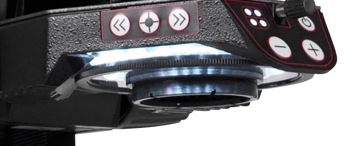 Zbliżenie mikroskopu z podświetlonymi przyciskami sterującymi; oświetlająca płytkę próbną umieszczoną poniżej.