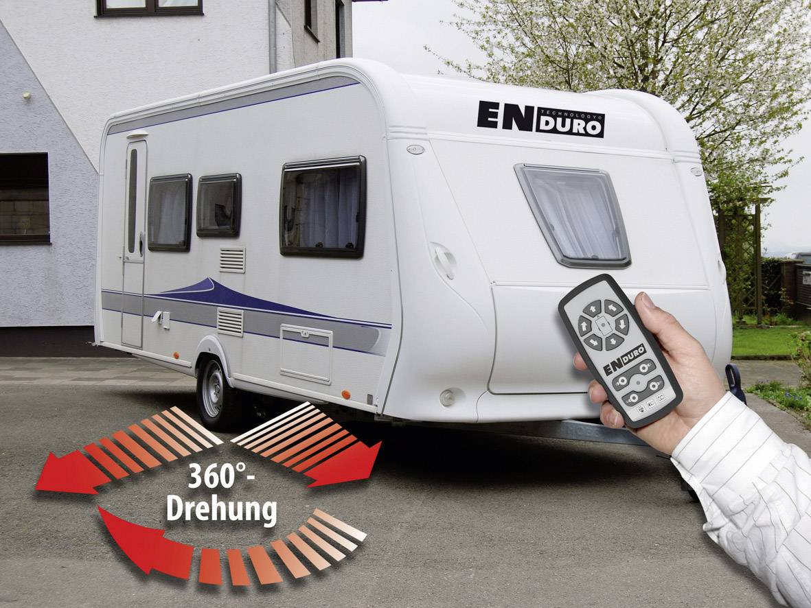Przyczepa kempingowa z pilotem do obracania o 360 stopni, zaparkowana przed budynkiem. Napis na przyczepie: 'ENDURO'.