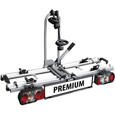 Srebrny bagażnik rowerowy na hak holowniczy, mieszczący dwa rowery. Na tabliczce widnieje napis 'PREMIUM'.
