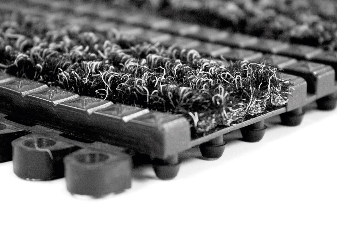 Zbliżenie na mata tekstylne z antypoślizgowymi gumowymi stopkami. Struktura maty jest gruba i wytrzymała.