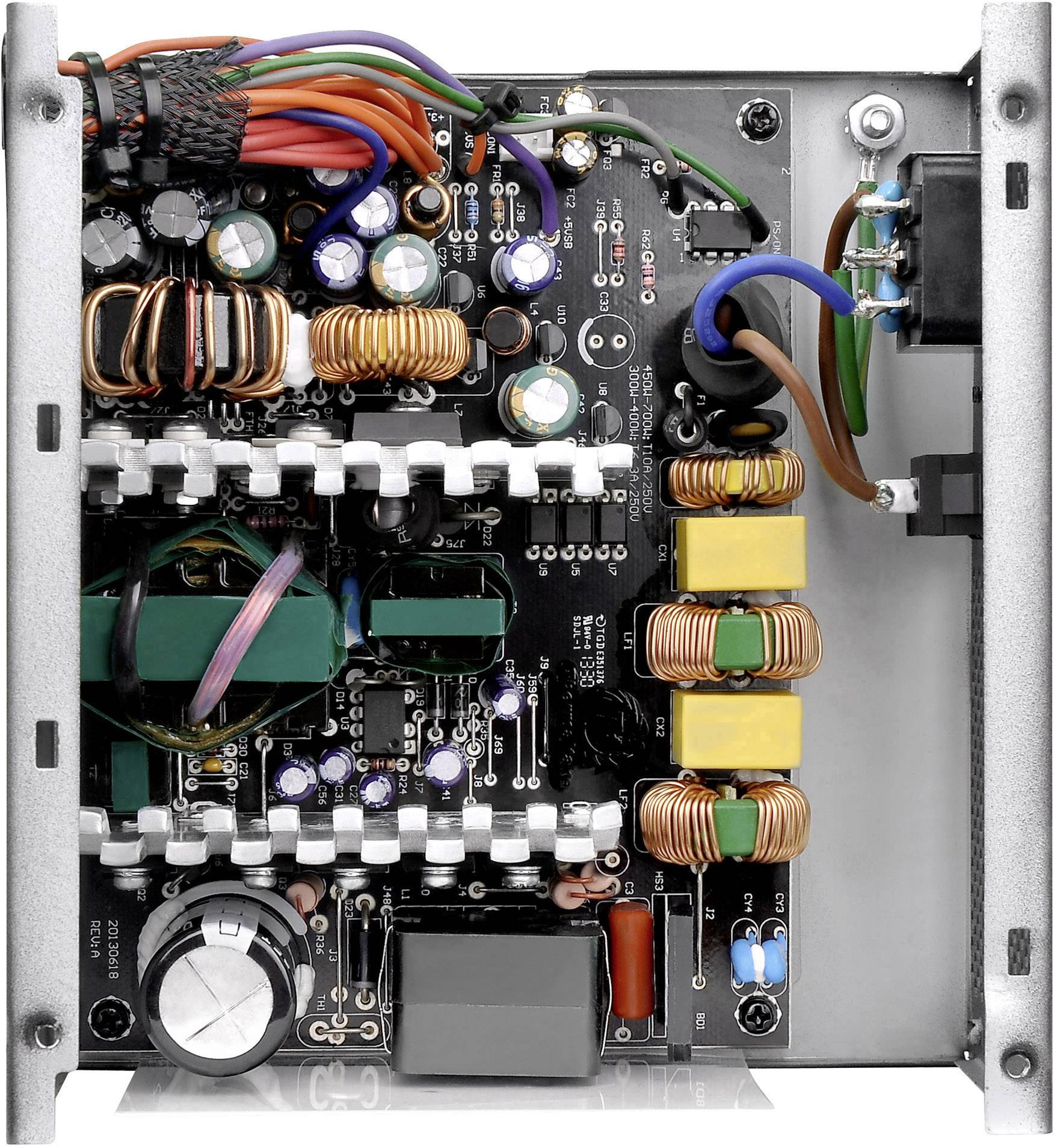 Elektroniczna płytka drukowana zasilacza z różnymi komponentami, takimi jak kondensatory, cewki i przewody. Widok wewnętrzny.