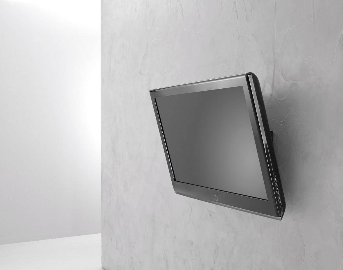 Płaski telewizor zamontowany pod skosem na szarej ścianie; minimalistyczny design; bez widocznych kabli lub dekoracji.