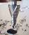 Kužeľový vrták prevŕtava kovovú dosku. Kovové triesky obklopujú vyvŕtaný otvor. Scéna zachytáva moment vŕtania.