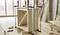 Drevená skriňa počas montáže, pridržiavaná niekoľkými svorkami na pracovnom stole v prostredí dielne.
