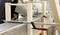 Osoba vyhladzuje čerstvý betón v drevenej forme pomocou hladidla, ktoré je upevnené dlhými svorkami.