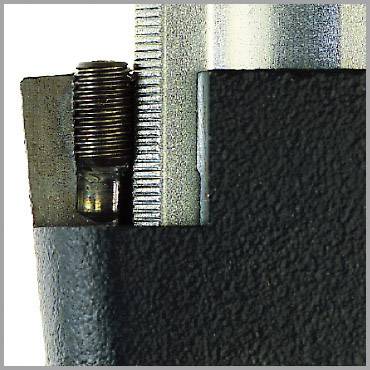 Detailný záber kovovej súčiastky so skrutkovým závitom a štruktúrovaným povrchovým vzorom, pravdepodobne súčasť väčšieho mechanizmu.