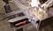 Osoba brúsi kov, pričom lietajú iskry. V popredí je viditeľná svorka s červeným držadlom, ktorá upevňuje obrobok.