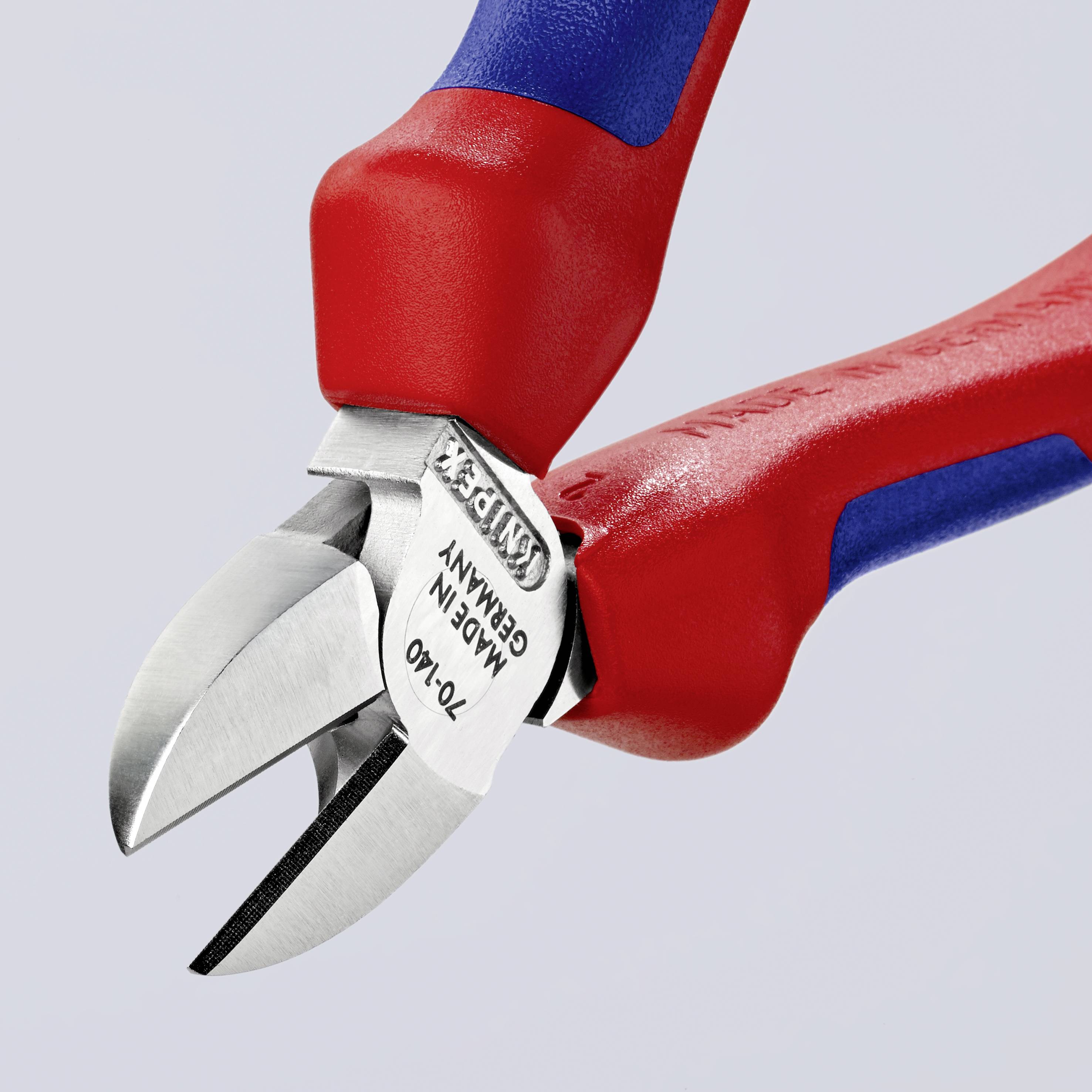 Červené a modré kliešte s nápisom "Made in Germany" strihajú drôty pred šedým pozadím.