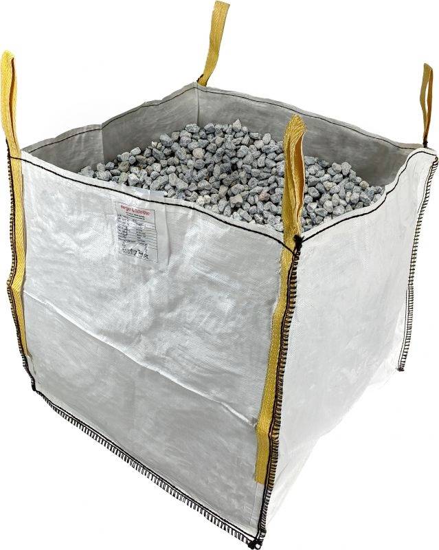 Veľký biely Big Bag, naplnený malými sivými kameňmi. Štyri žlté úchyty na rohoch pre jednoduché prenášanie.