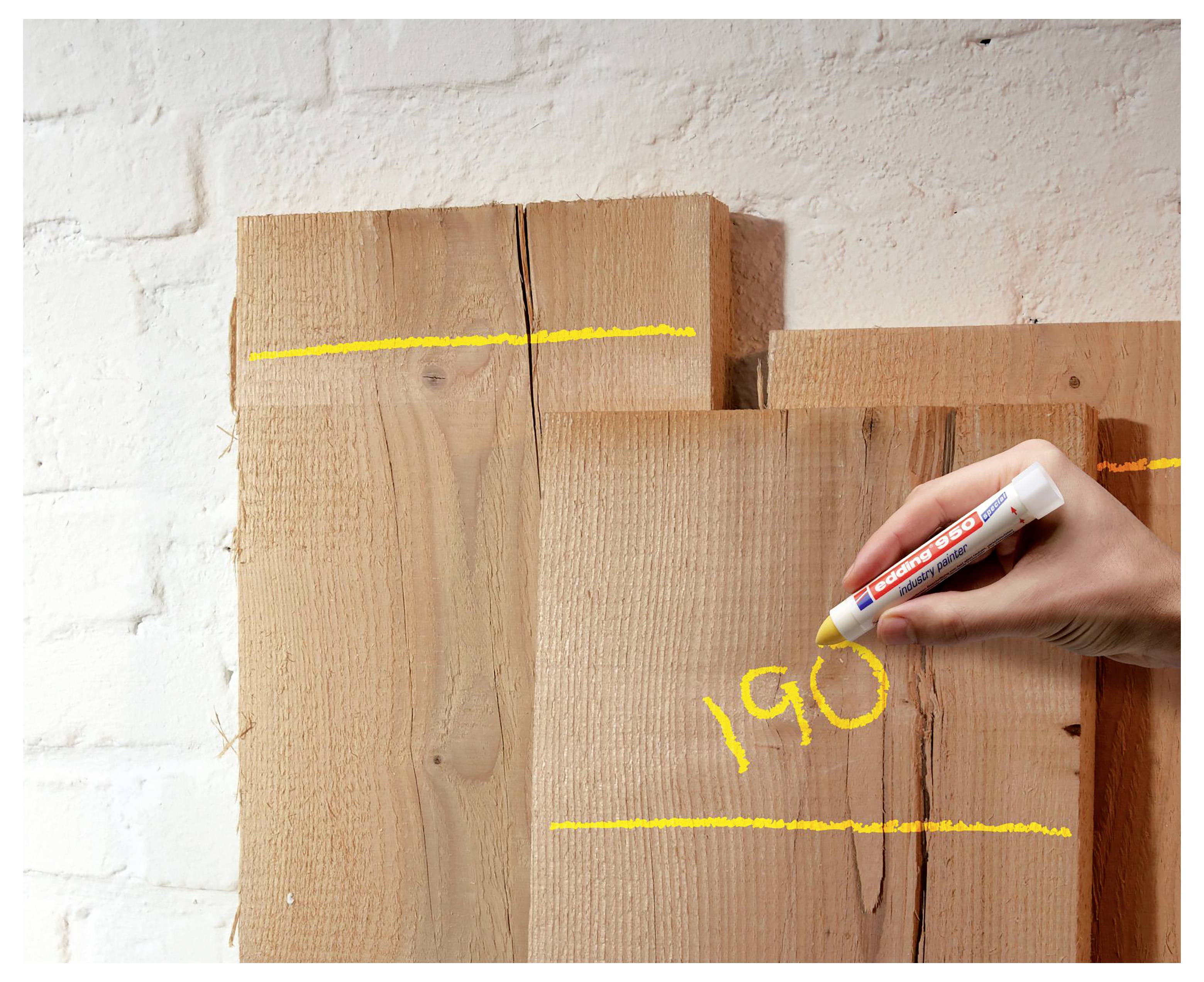 Ručné písmo čísla „190" napísané žltým fixom na stackovaných drevených doskách pred bielou murivom.