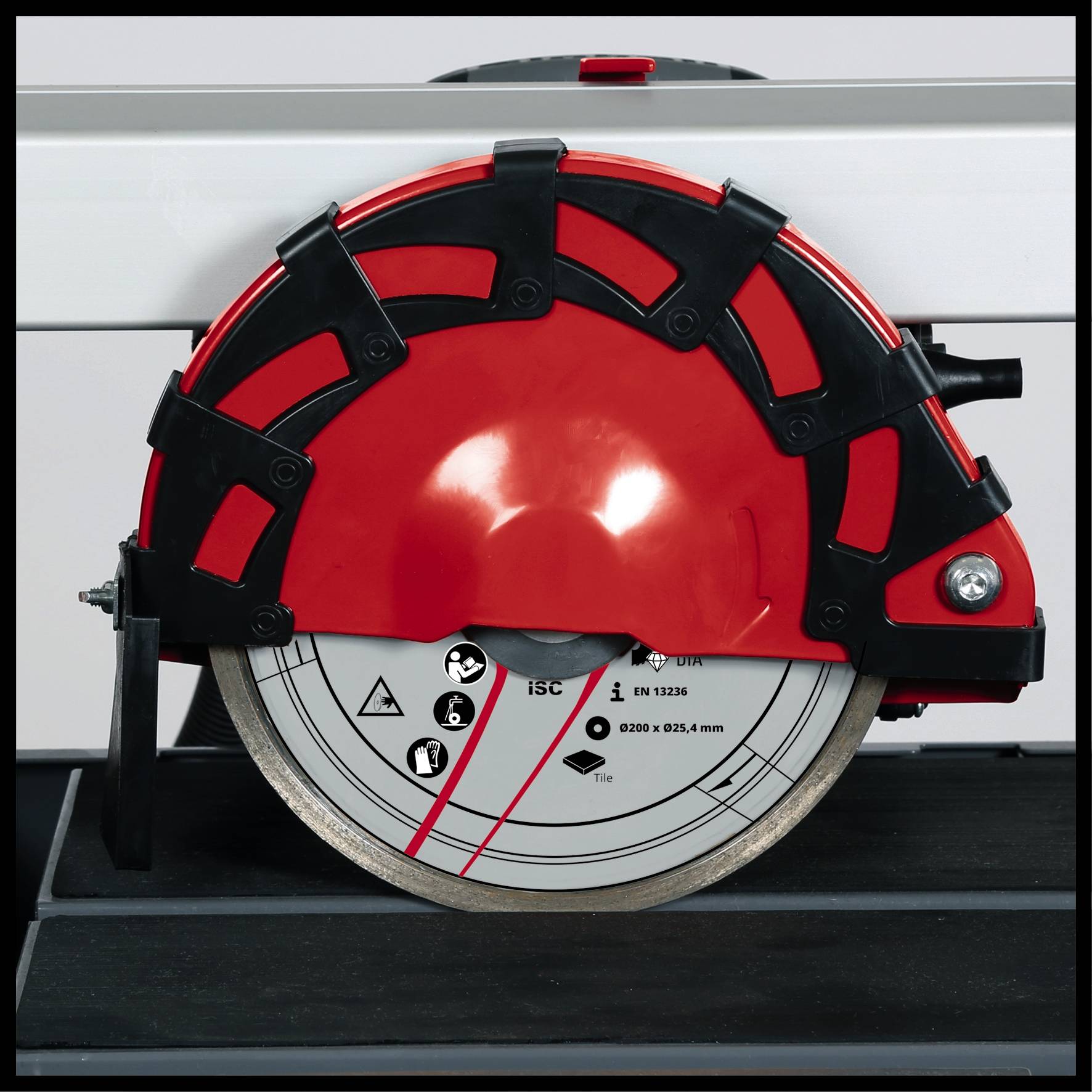 Guľatá, rotačná kotúčová píla s ochranným krytom, umiestnená na čiernom pozadí. Čepeľ zobrazuje symboly bezpečného použitia.