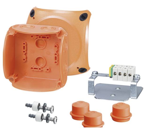 Oranžová plastová inštalačná krabica pod omietku, otvorená vedľa svoriek, krytov a príslušenstva. Súčasť elektroinštalačnej súpravy.