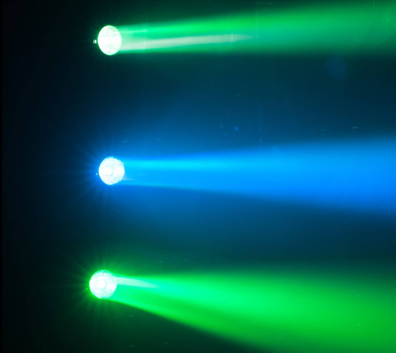 Tri reflektory svietia v tme: jeden zelený a jeden modrý hore, ďalší zelený dole.