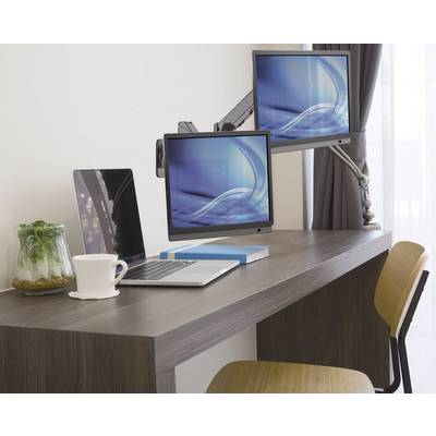 Minimalistické pracovisko s laptopom, dvoma monitormi, knihou, šálkou a rastlinou na drevenom stole.