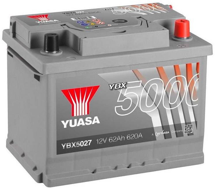 Šedá autobatéria s červeným a čiernym vývodom. Nápis: 'YUASA YBX 5000, 12V 62Ah 620A'.