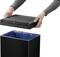 Osoba odstraňuje veko čierneho odpadkového koša. Kôš obsahuje modrý odpadový vrece.